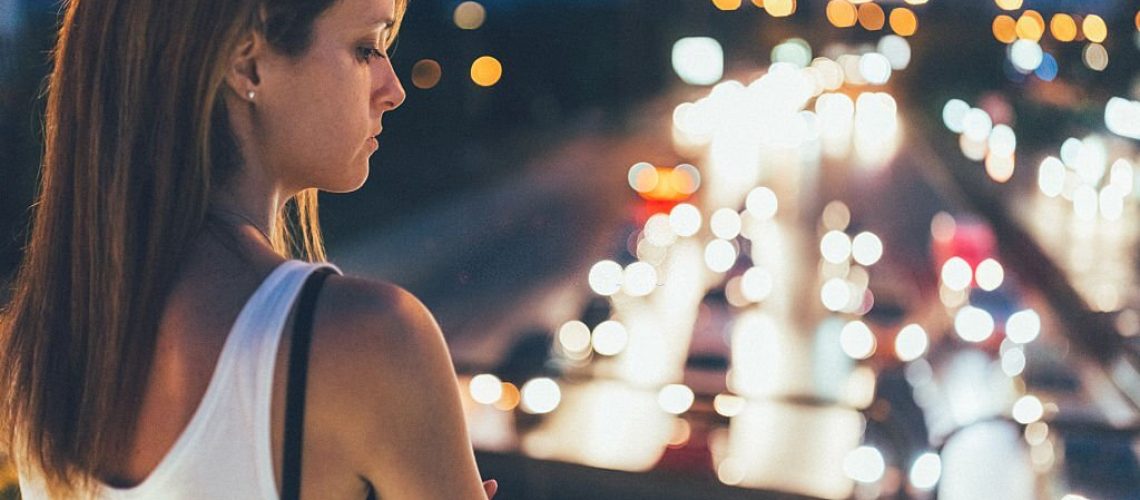 Thoughtful woman outside at night